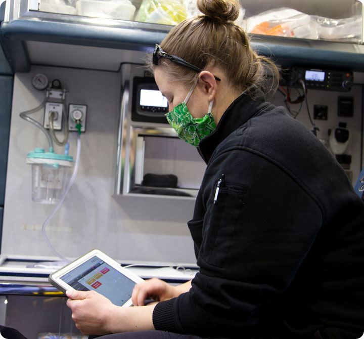 EMS technician in back of ambulance using FirstNet tablet device 
