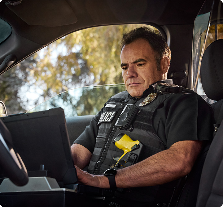 Police officer using laptop in a vehicle