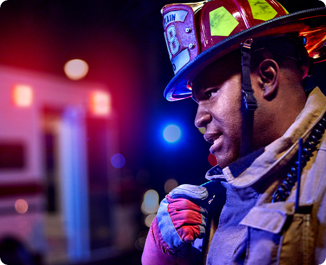 Firefighter on scene using push-to-talk device in emergency 