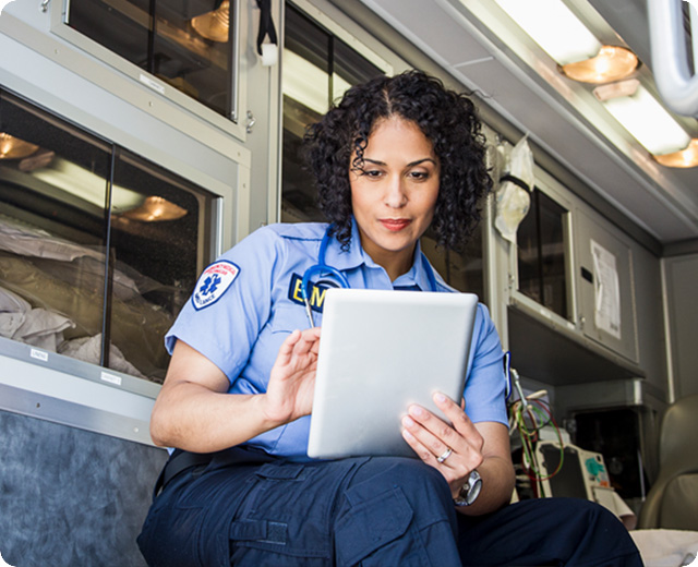 EMT using a tablet inside an ambulance